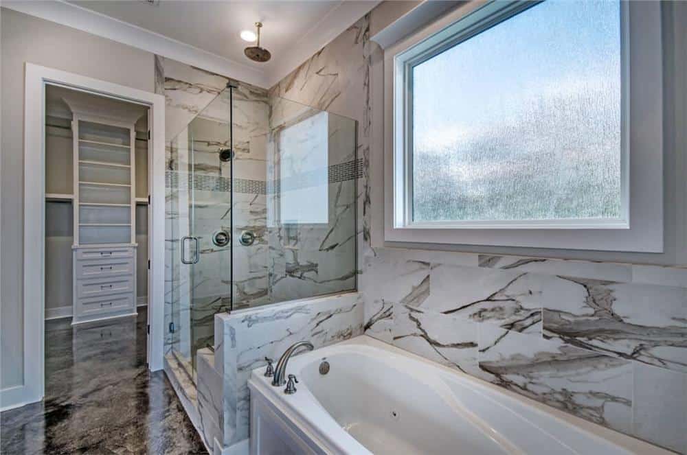 步入式淋浴间和落地窗下的浴缸构成了主浴室。