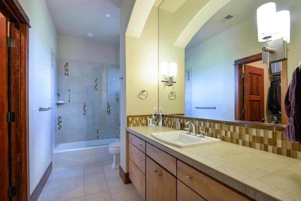 浴室配有大型梳妆台，卫生间和浴缸和淋浴组合米色马赛克瓷砖。