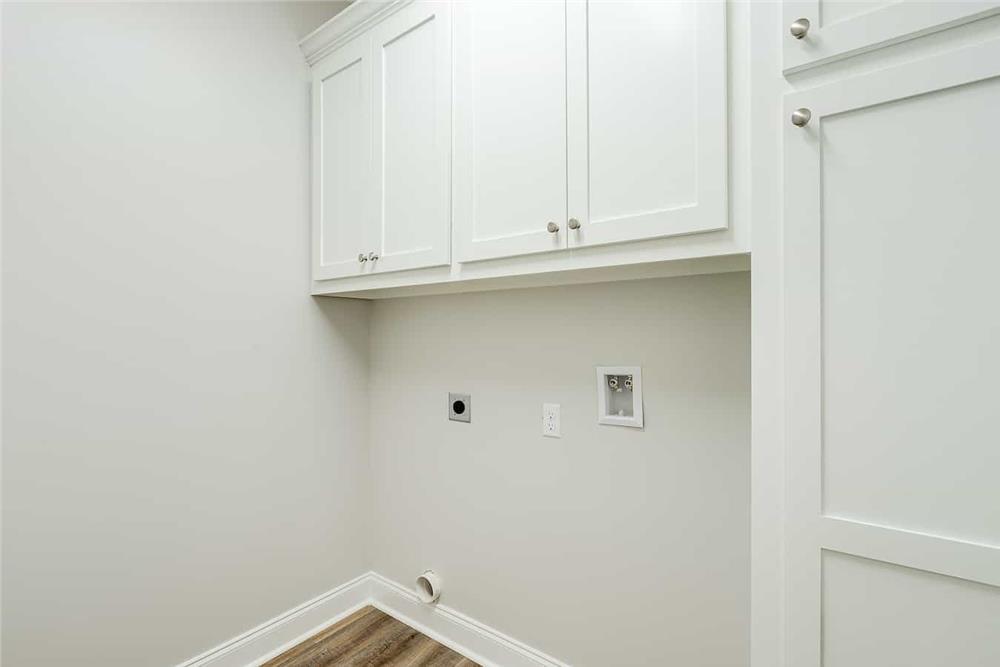 洗衣房上方有白色的橱柜，与墙壁融为一体。