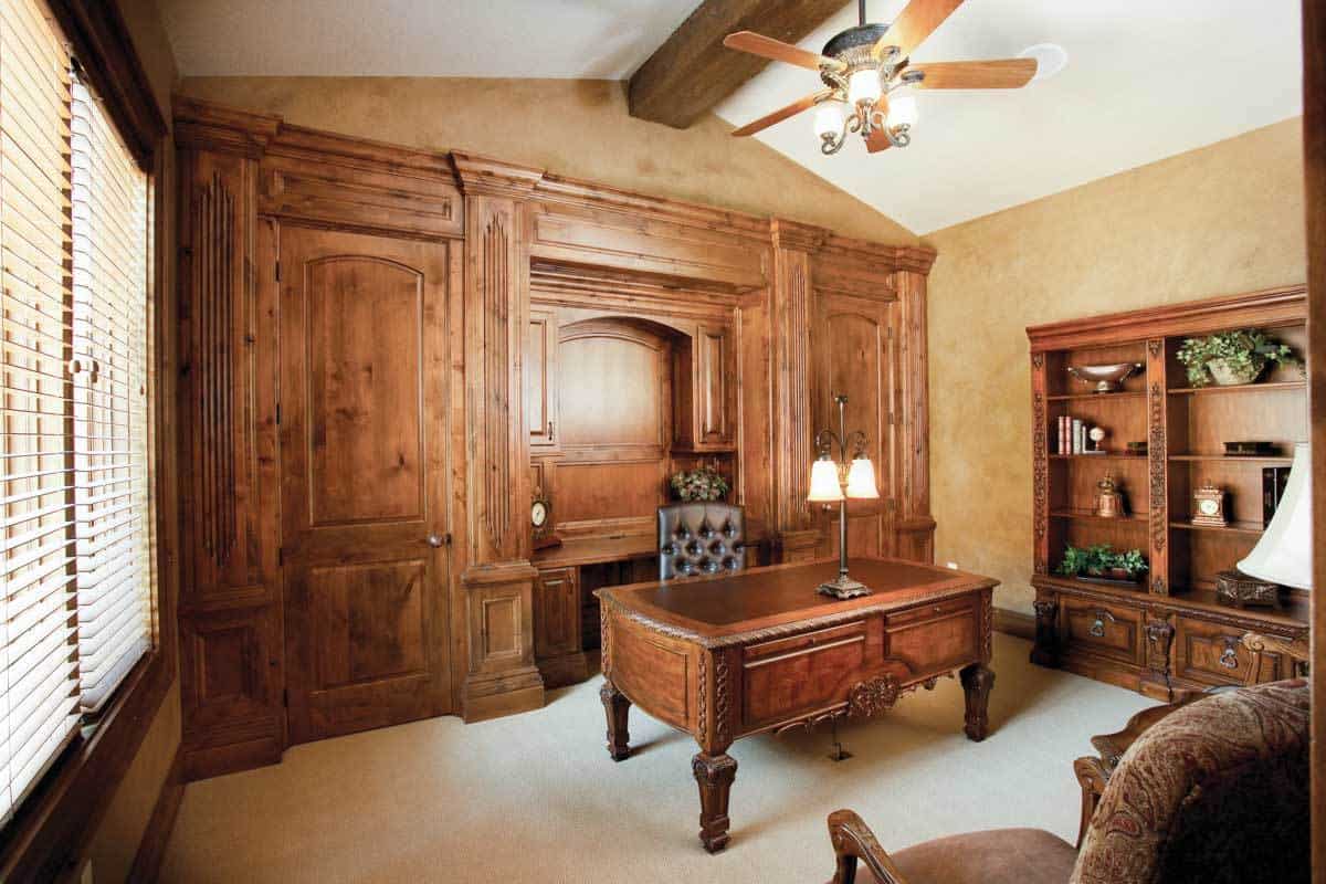 书房里有木质的内置家具，米黄色的墙壁，以及带有裸露木梁的拱形天花板。