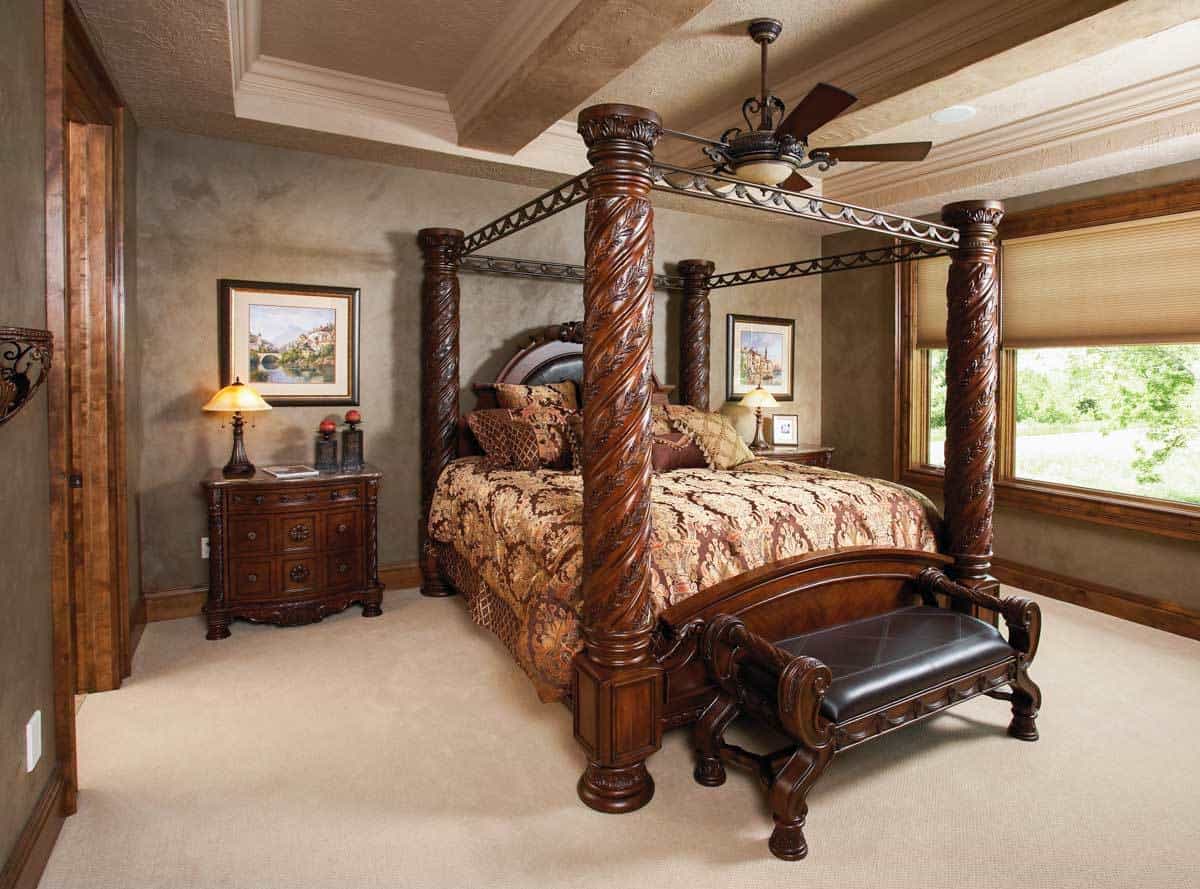 主卧室带有托盘天花板和复杂的四柱床，并配有皮革软垫长椅。