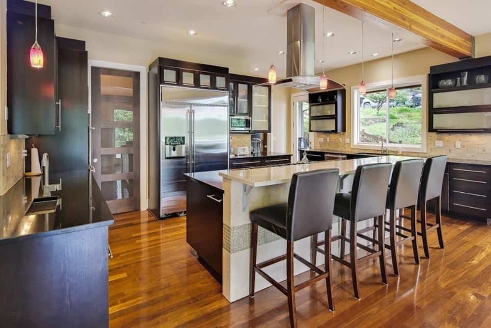 厨房配备了不锈钢器具、深色木制橱柜和一个带抬高吧台的早餐岛。