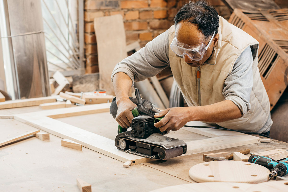 木匠使用角磨床在木制家具上工作。