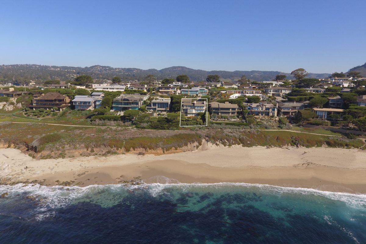 一个居民区的正面鸟瞰图，俯瞰着白色的沙滩和沿着海岸线的岩石。图片来自Toptenrealestatedeals.com
