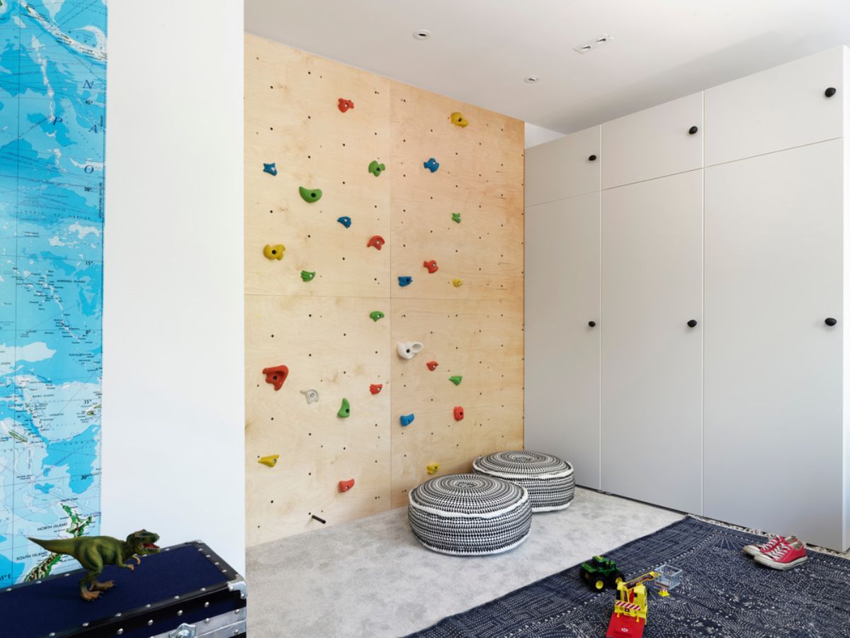 孩子们的卧室明亮、多彩、轻松，有一面定制的、有趣的落地攀岩墙，还有一张巨大的世界地图壁纸。