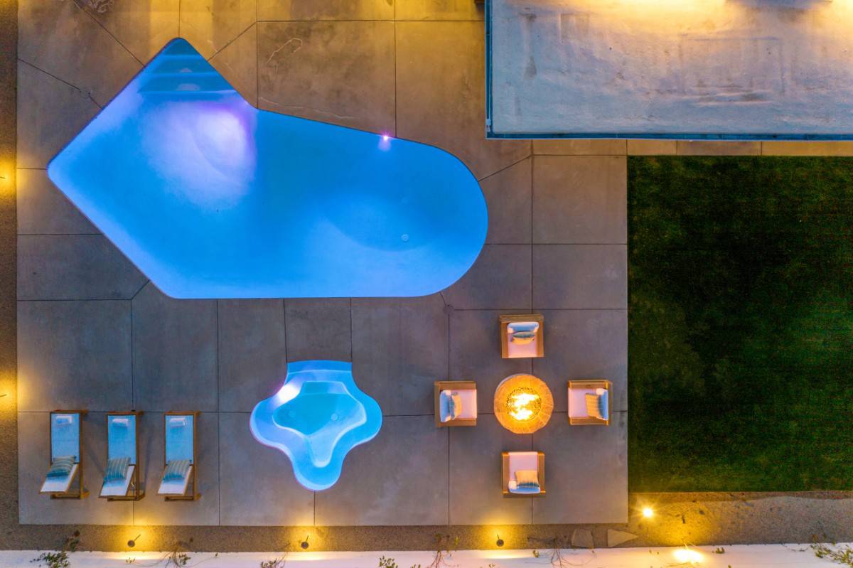 鸟瞰室外生活展示照明游泳池和水疗中心。图片来自Toptenrealestatedeals.com。