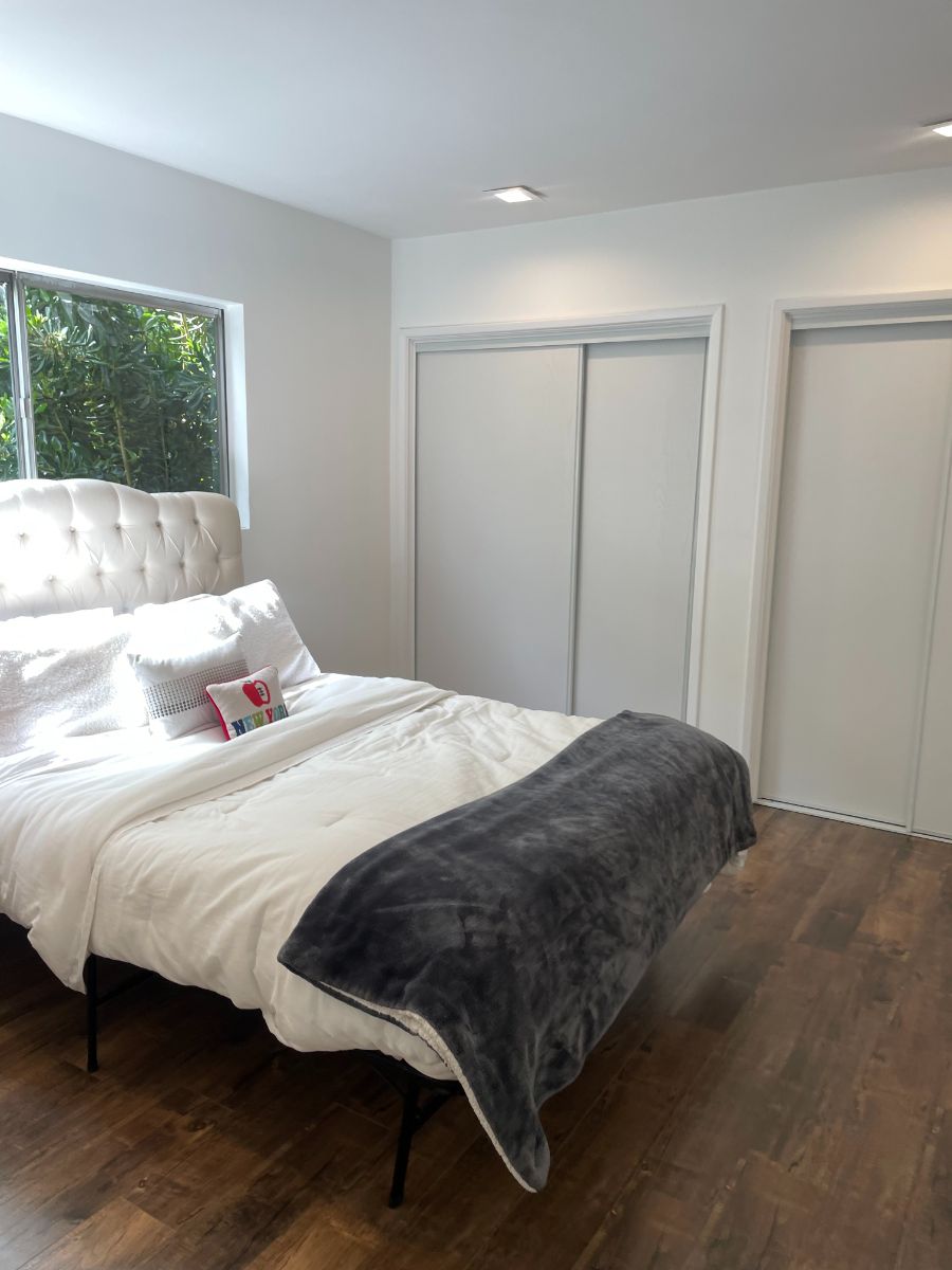 主卧室铺着硬木地板，带有极简主义风格的玻璃窗。