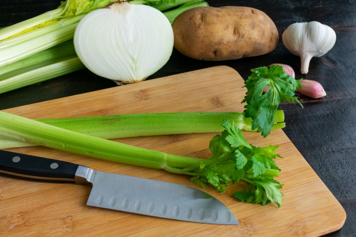 芹菜，土豆，洋葱和一块竹砧板。