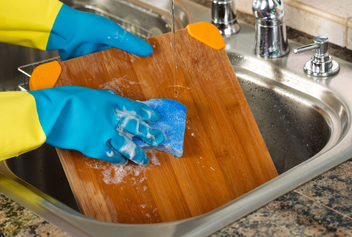 一个人防护手套清洗砧板。