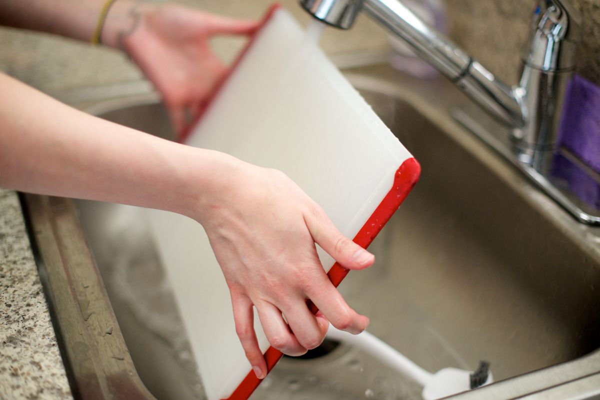 一个女人洗水槽的砧板。