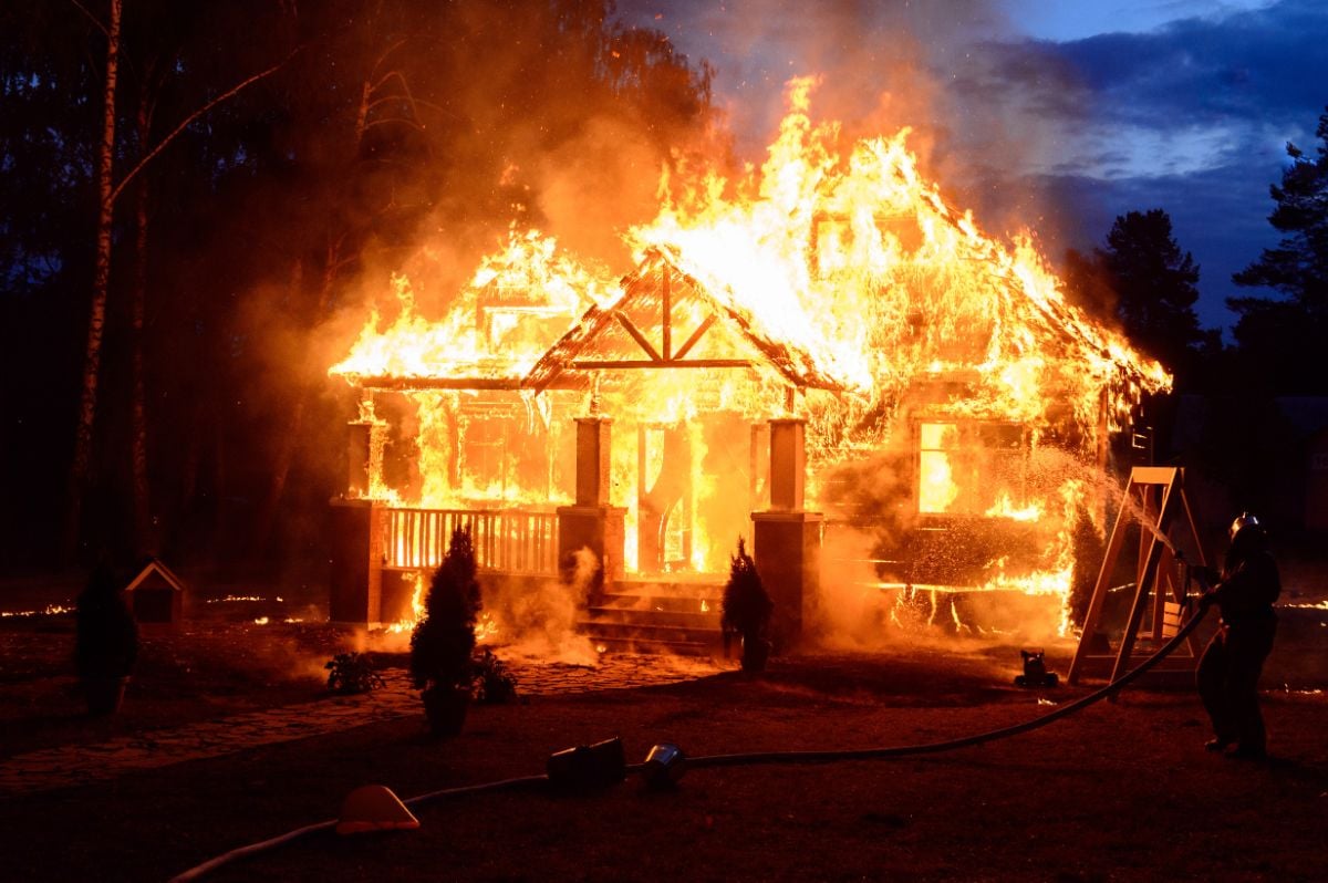一名消防员试图控制着火房屋的火势。