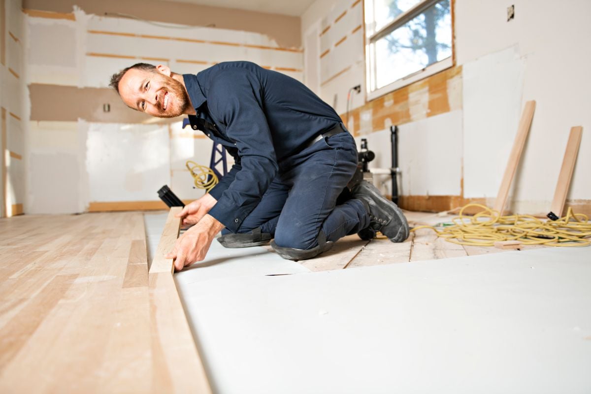 一个男人在地板上安装木板。
