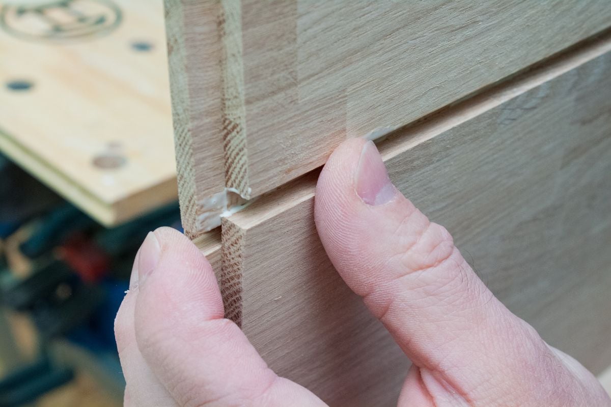 一名男子用木胶把两块木板粘在一起。