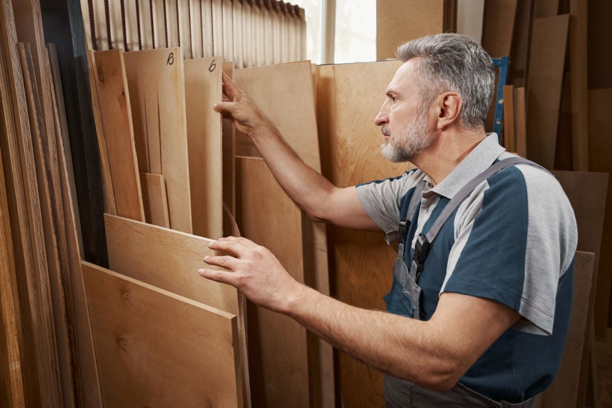 一个男人在为他的木制品挑选胶合板。