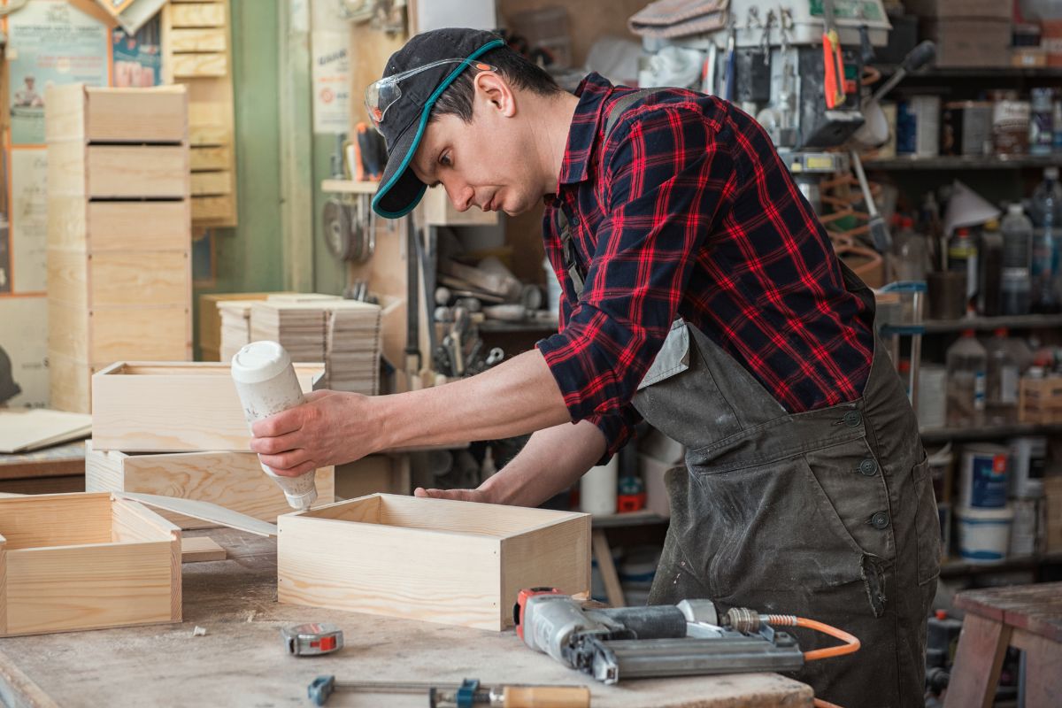 用木胶在木制家具上工作的人。