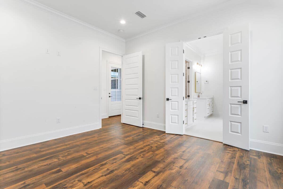 主卧室包括私人浴室用白色的双扇门。