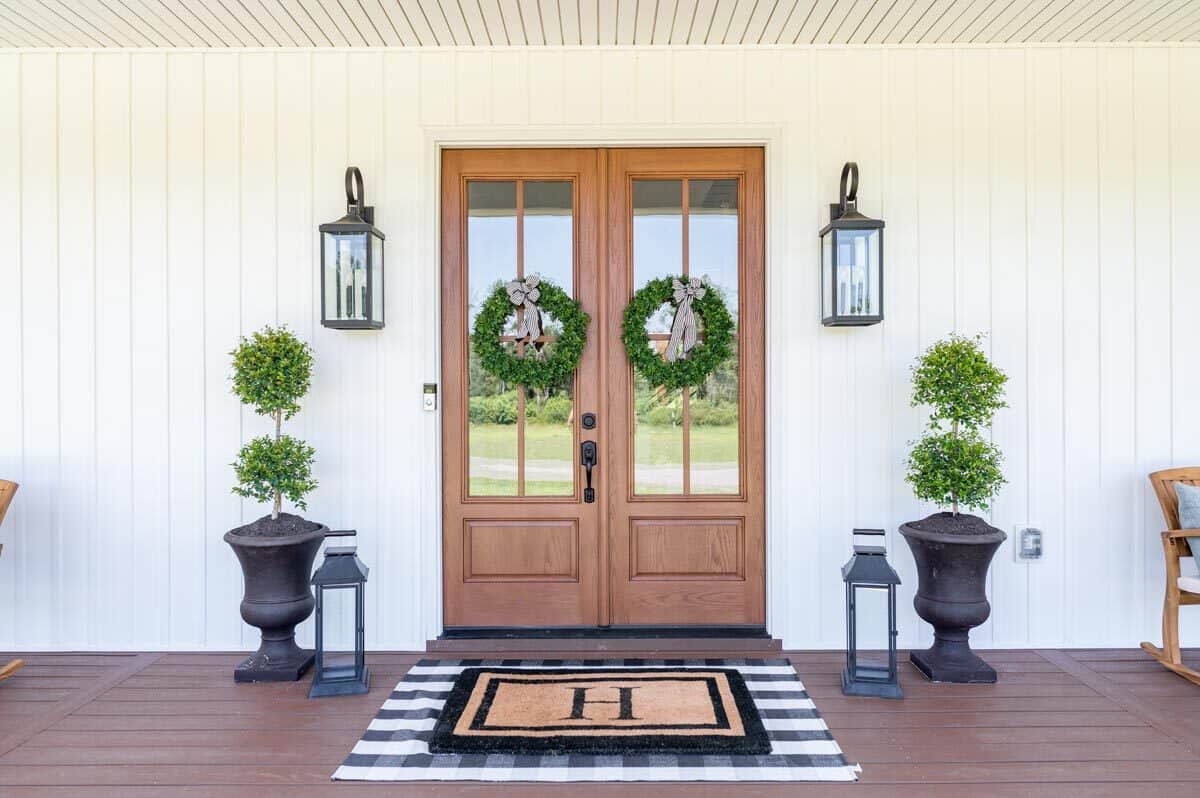 法式入口门装饰着花环，户外烛台，和植物基座。