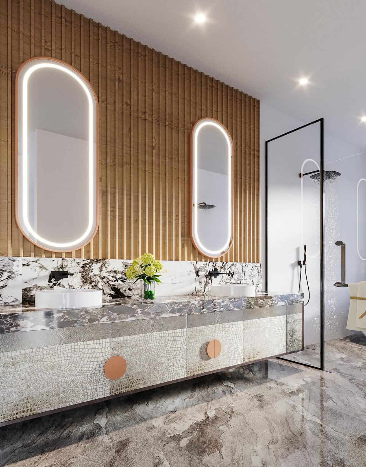 主浴室配有优雅的梳妆台，配有双水槽和发光的椭圆形镜子。