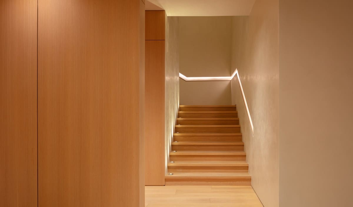 木楼梯也与橱柜和硬木地板相匹配，创造了无缝的外观。图片来自Toptenrealestatedeals.com。