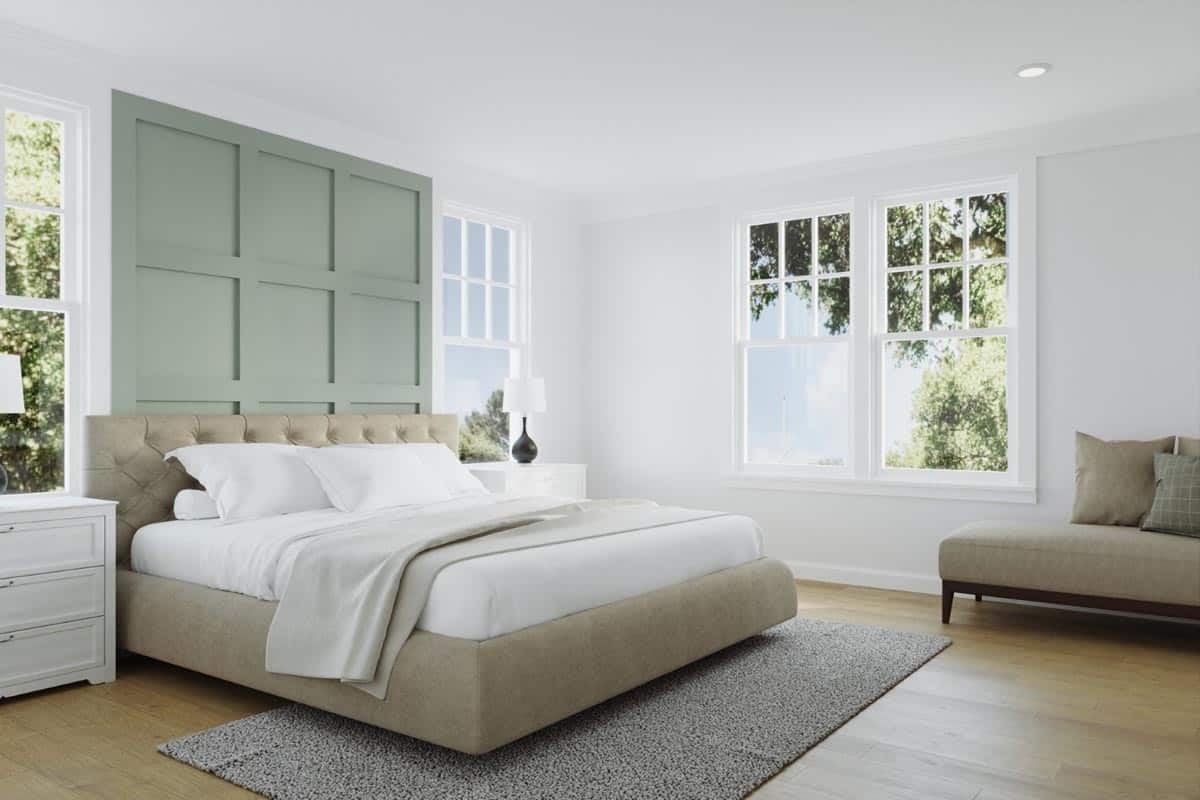 主卧室里铺着硬木地板，一张簇绒床被深绿色镶板的强调墙突出。