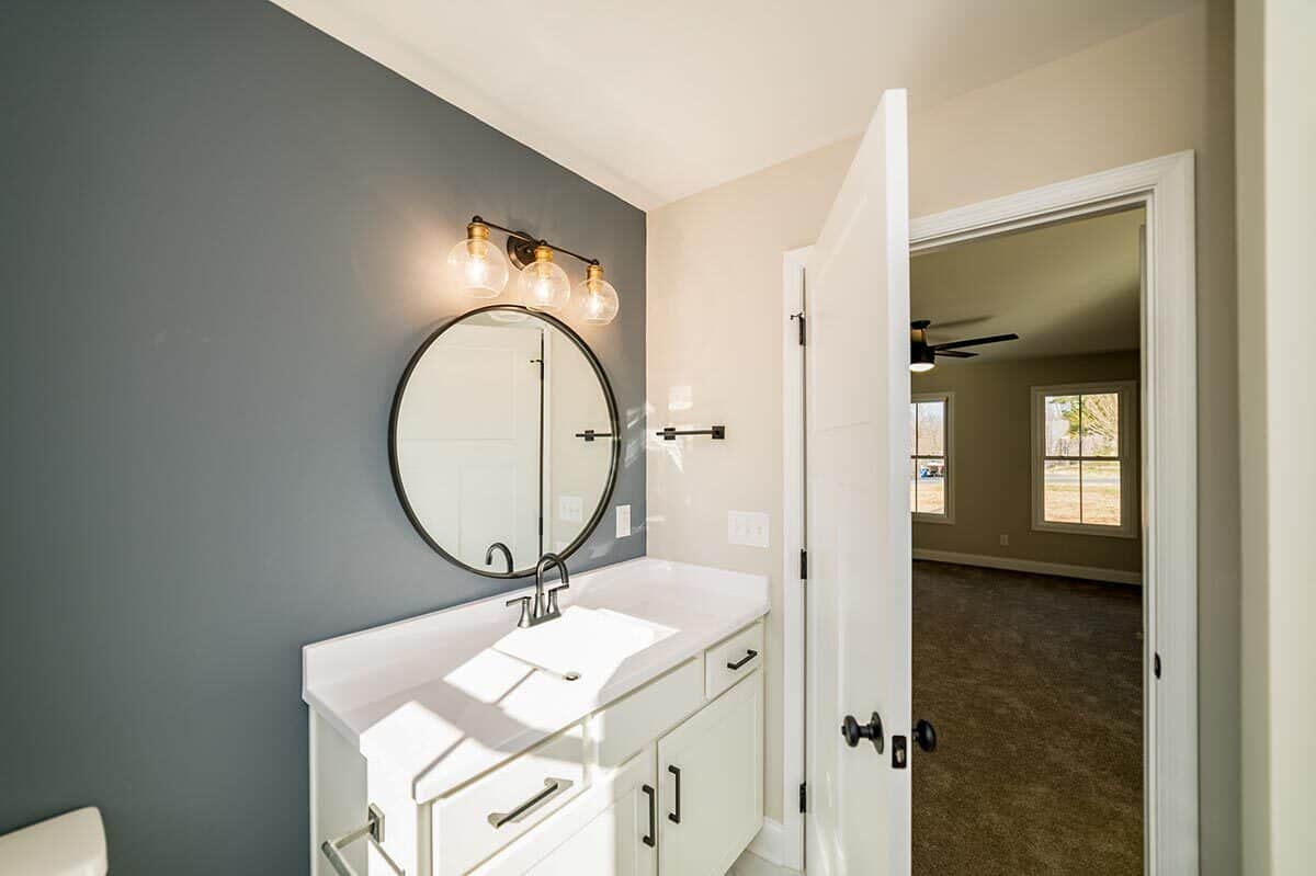 一个灰色的口音墙添加一个漂亮的对比白色的浴室。