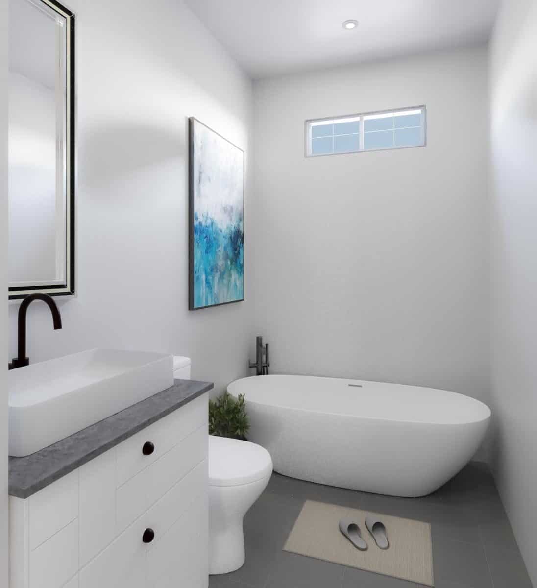 这间浴室有一个独立的浴缸和一个白色梳妆台，上面有一个水槽。