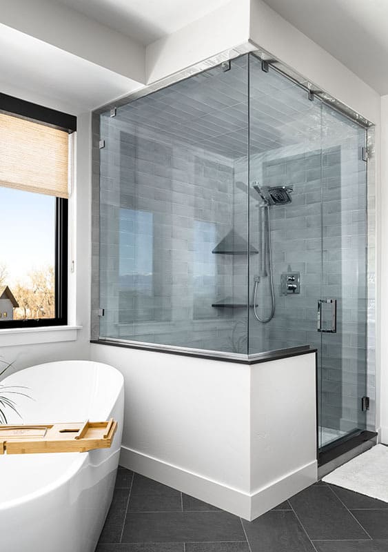 主浴室带有一个独立的浴缸和一个由玻璃铰链门包围的步入式淋浴。