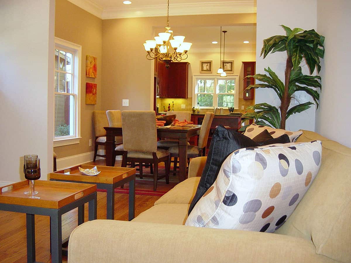 客厅里有两张咖啡桌和一个米色沙发，上面点缀着黑色和圆点的枕头。