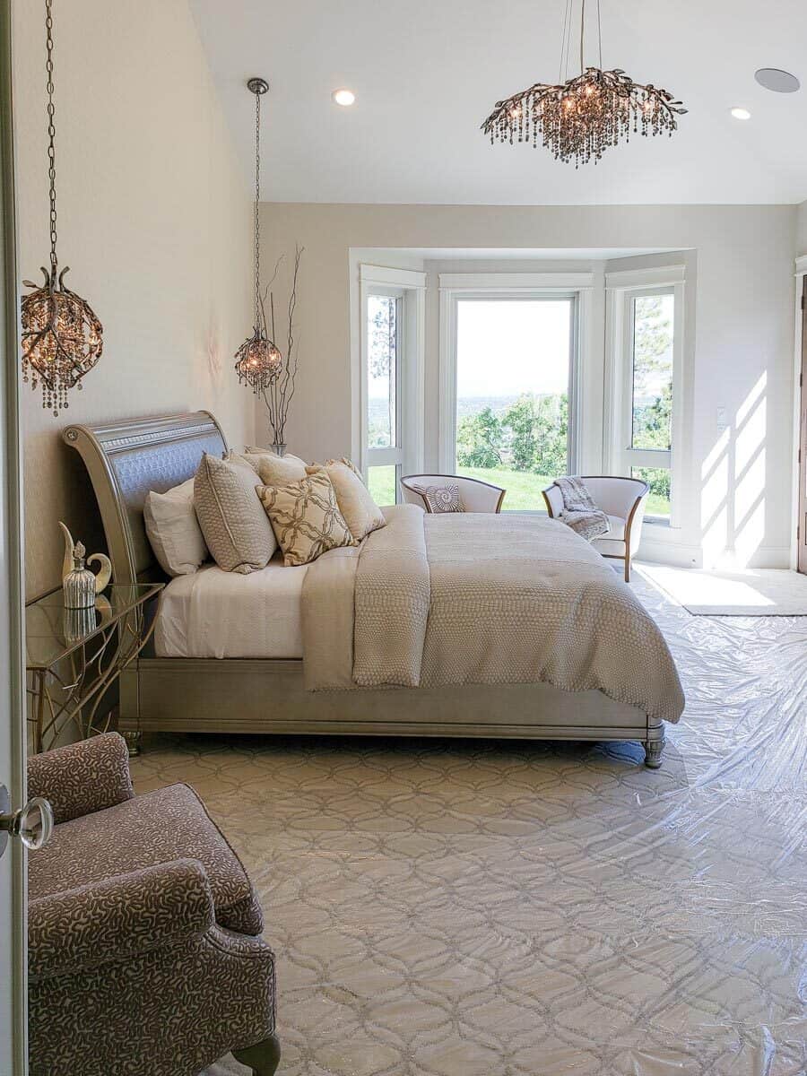 主卧室有一张木床，温暖的串珠吊坠，以及凸窗旁的休息区。
