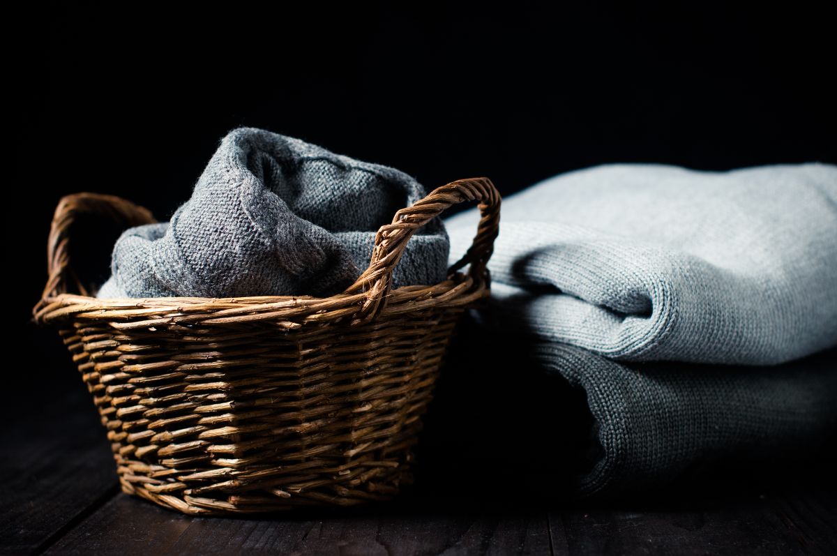 羊毛毯子放在编织的篮子上。
