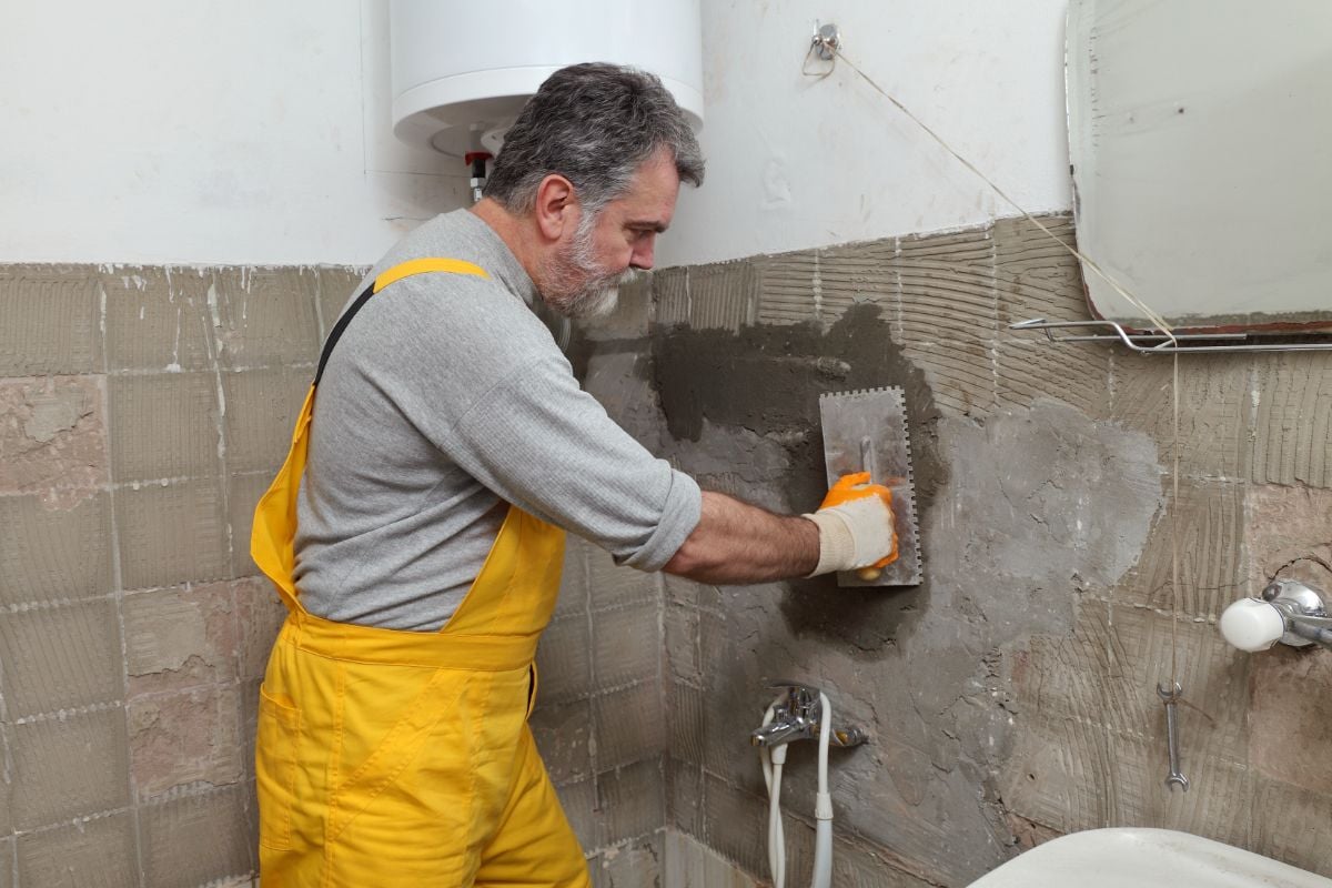 一位老工人正在装修浴室。