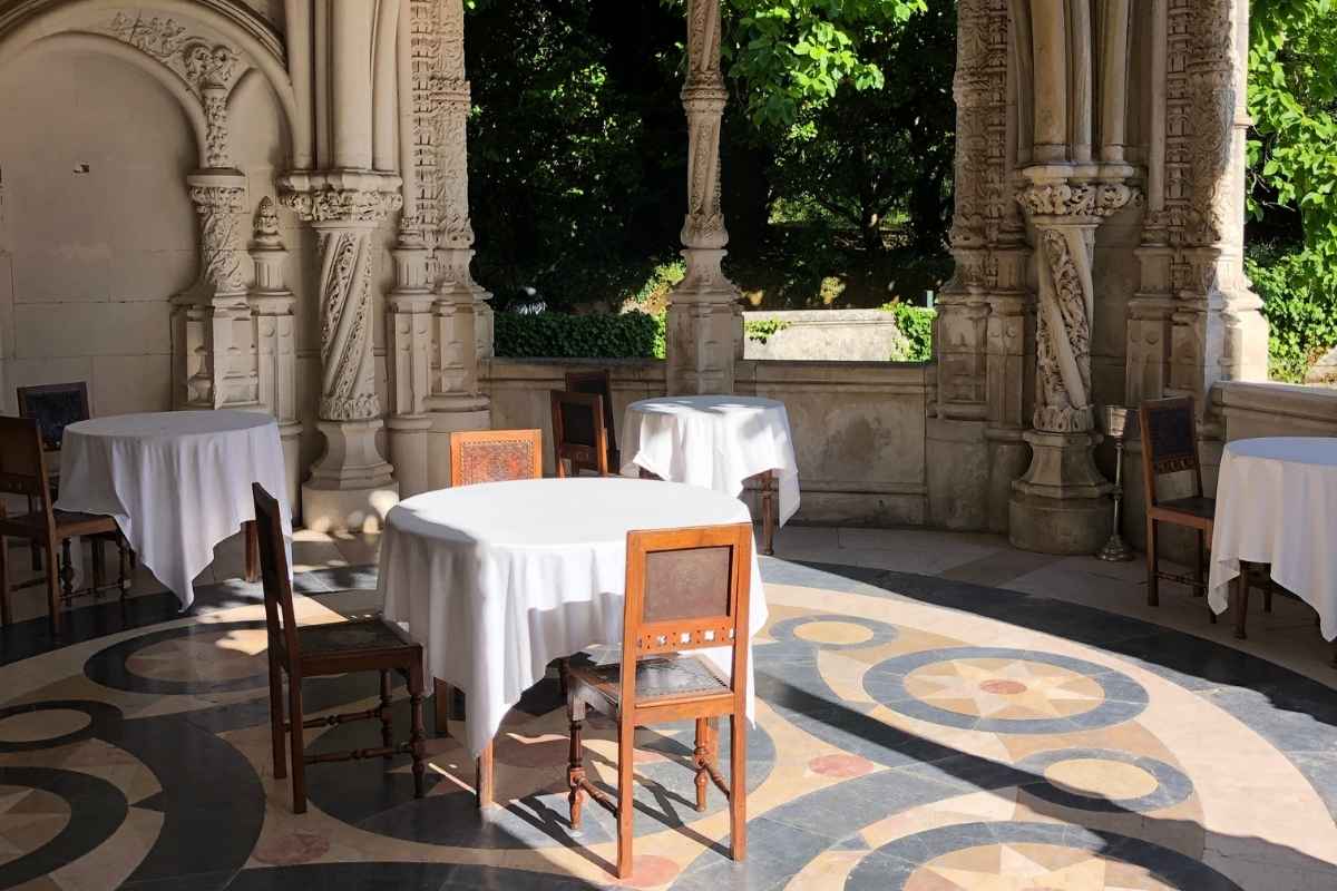 古典希腊风格的庭院，木椅和桌子覆盖着织物。