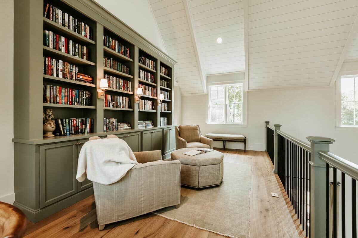 图书馆阁楼，内置书柜，米色扶手椅，八角形凳，和靠窗的软垫长椅。