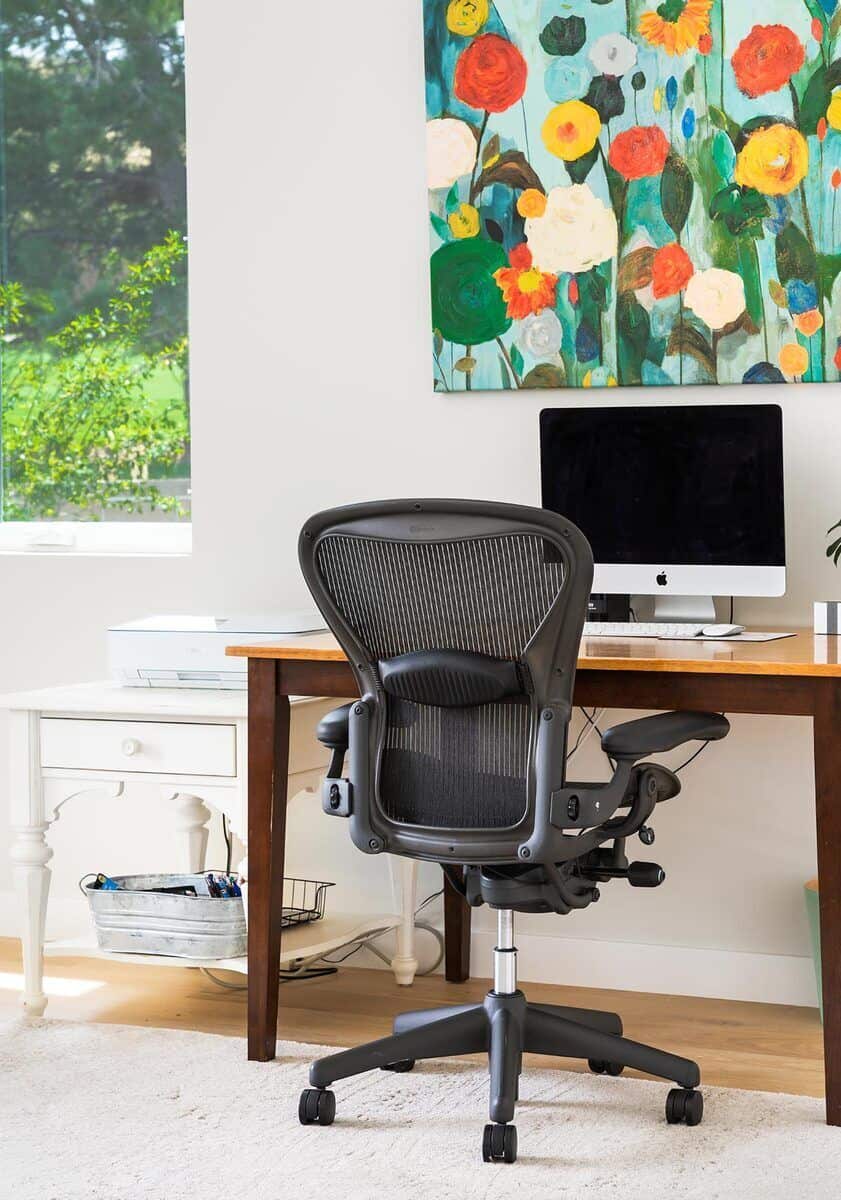 一件花卉艺术品为白色的家庭办公室增添了鲜艳的色彩。