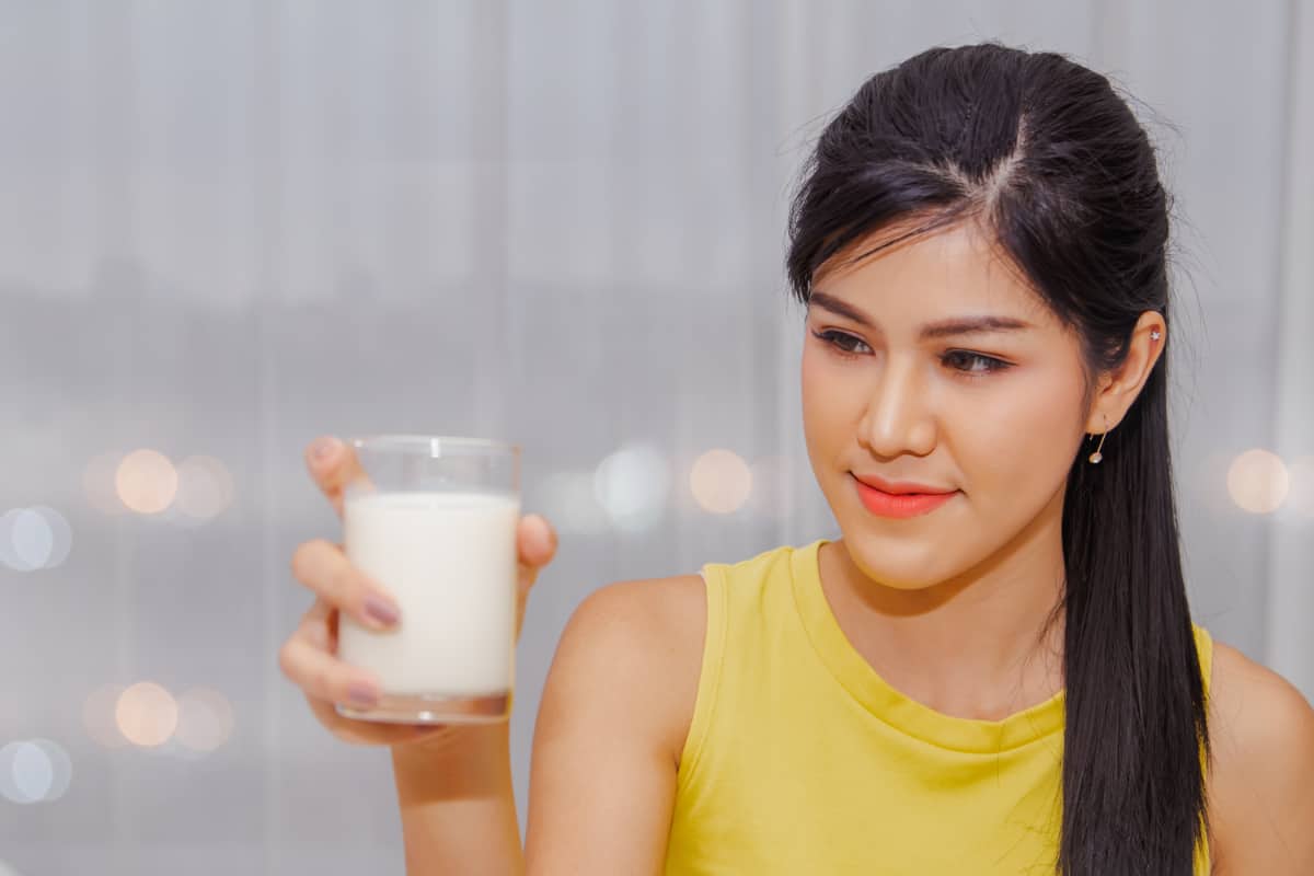 女人正在喝一杯牛奶。