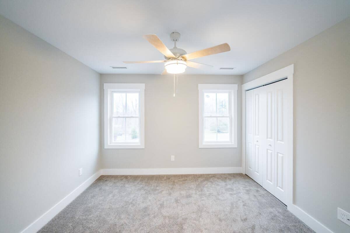 第二个卧室地毯的地板上,一个大壁橱,邀请自然光的白色框架窗口。