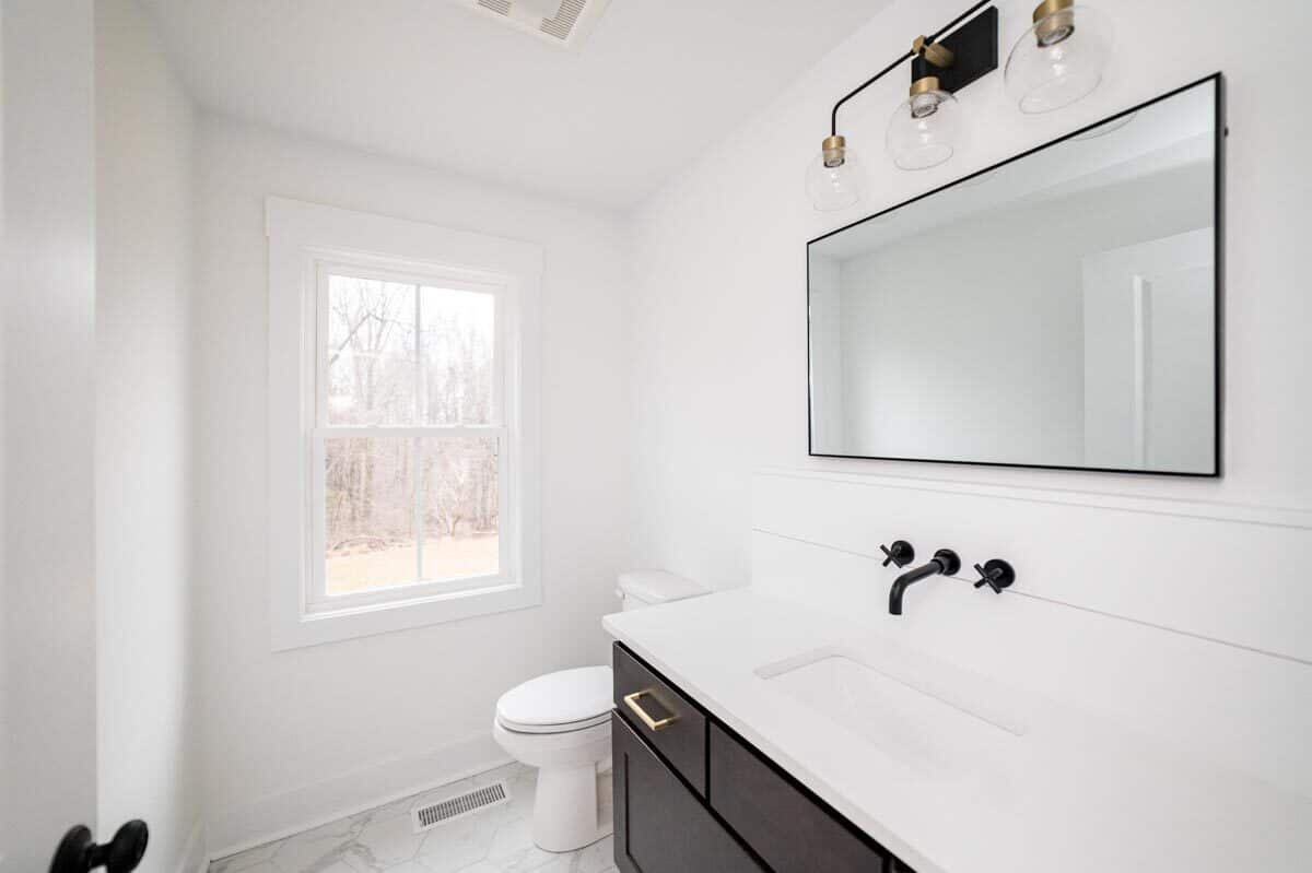 这个浴室的白墙形成对照的是,黑暗的木橱柜的虚空。