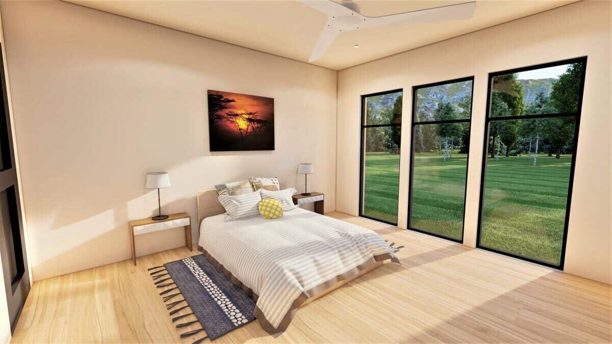主卧室与光硬木地板和高大的窗户俯瞰郁郁葱葱的院子里。