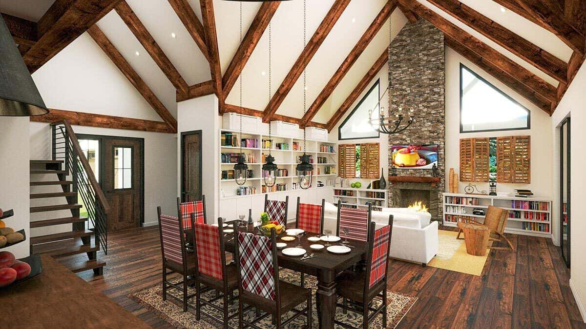 餐厅和客厅相结合，有一座石砌壁炉、高窗和高耸的拱形天花板，天花板上有裸露的乡村横梁。