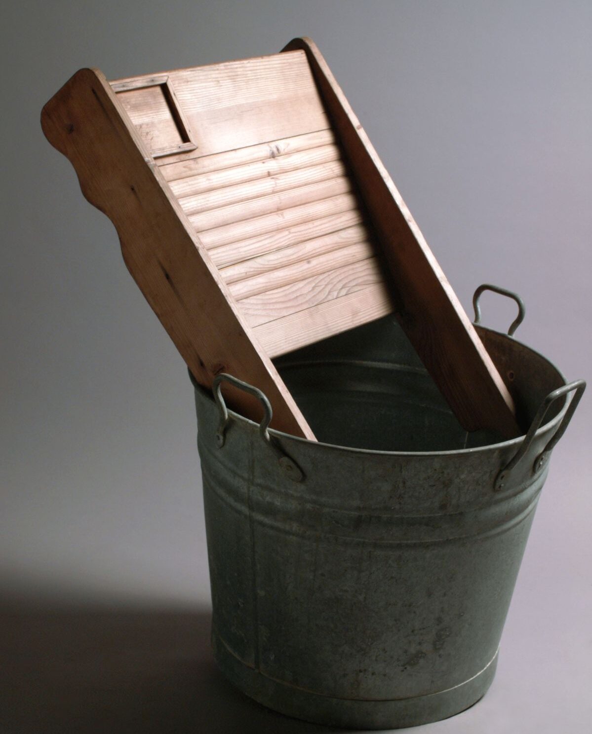 带木制工具的金属洗衣桶。