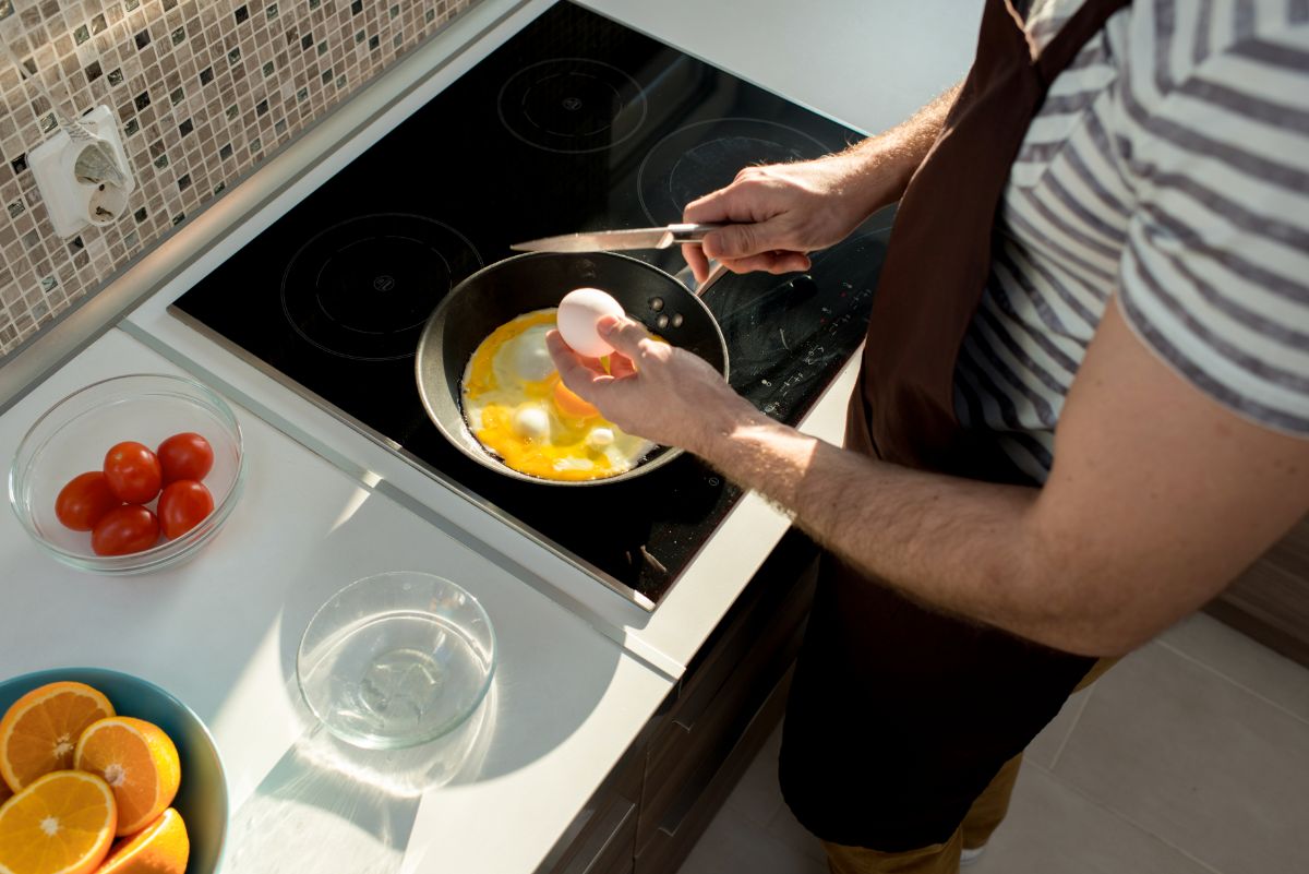 一个男人在灶台上煮鸡蛋。