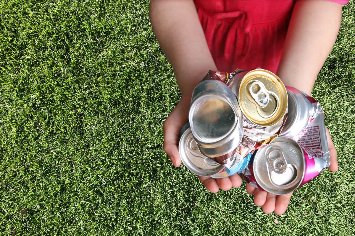草坪上一个拿着铝罐的孩子。