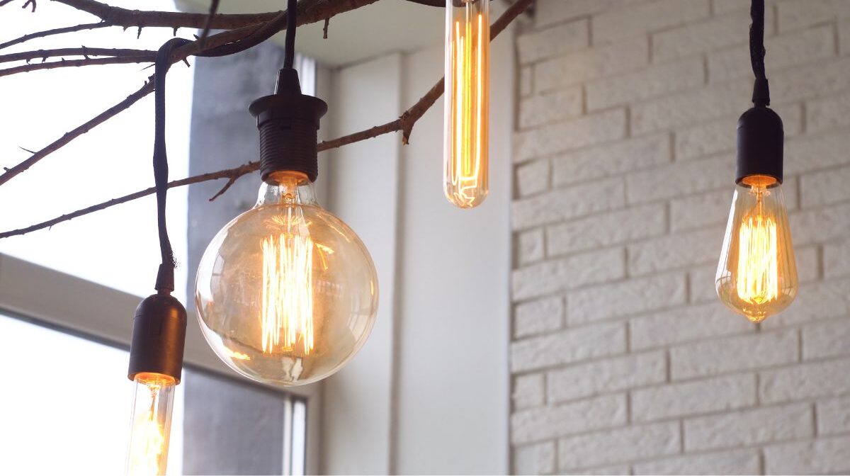 近距离的照片，一个封闭的led灯泡挂在一个木制道具设计美学。