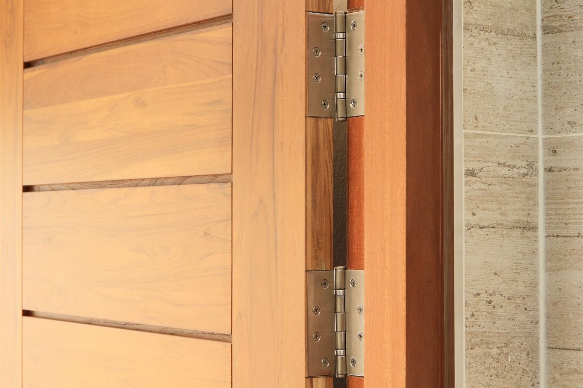 靠近照片的不锈钢门铰链在一扇木门。