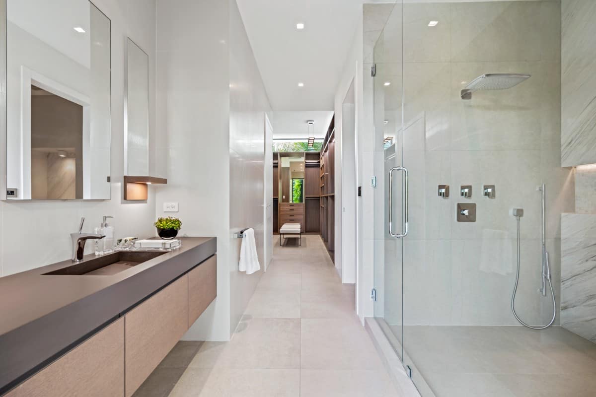 这间浴室设有一个漂浮的梳妆台，一个玻璃封闭的淋浴区和一个步入式衣橱。图片来自Toptenrealestatedeals.com。