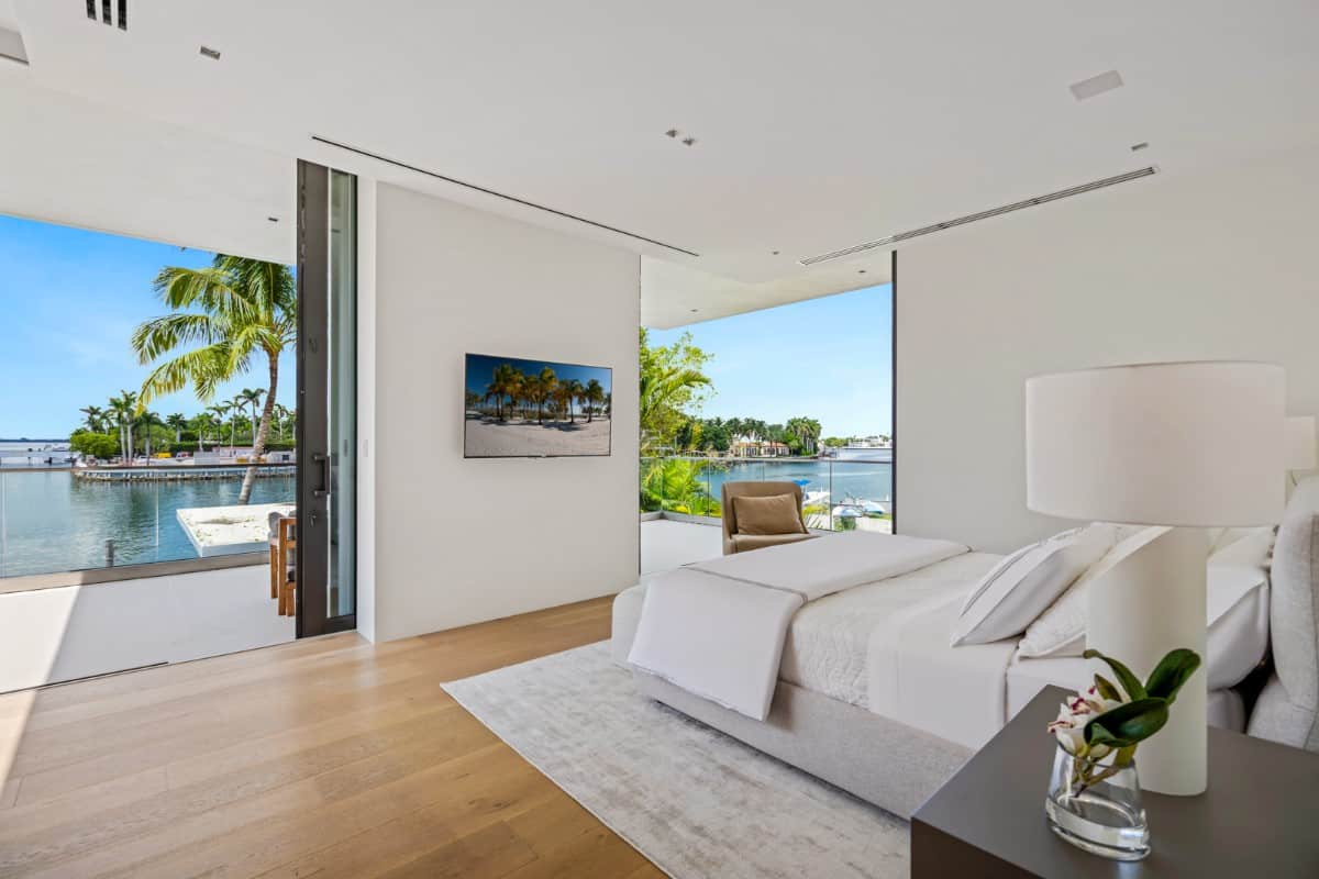 这间卧室有一台壁挂式电视和一个露台，可以看到美丽的海滩景色。图片来自Toptenrealestatedeals.com。