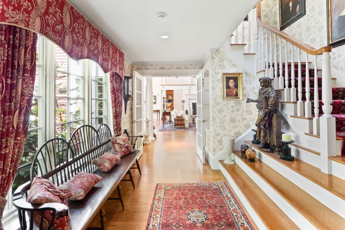 门厅里有一条细长的木凳和一个装饰着雕塑的楼梯。图片来自Toptenrealestatedeals.com。