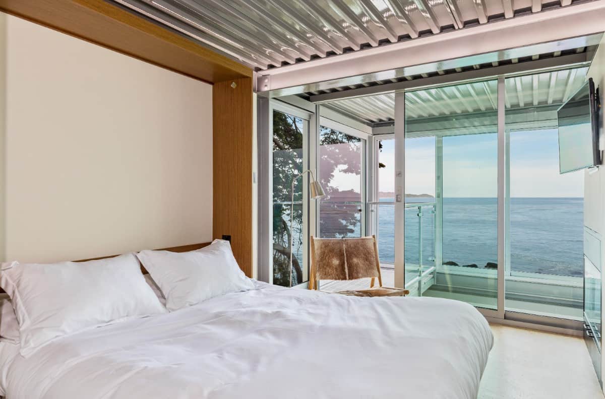 定制的床在这间卧室里是镜像的。它包括一台壁挂式电视和广阔的海景。图片来自Toptenrealestatedeals.com。