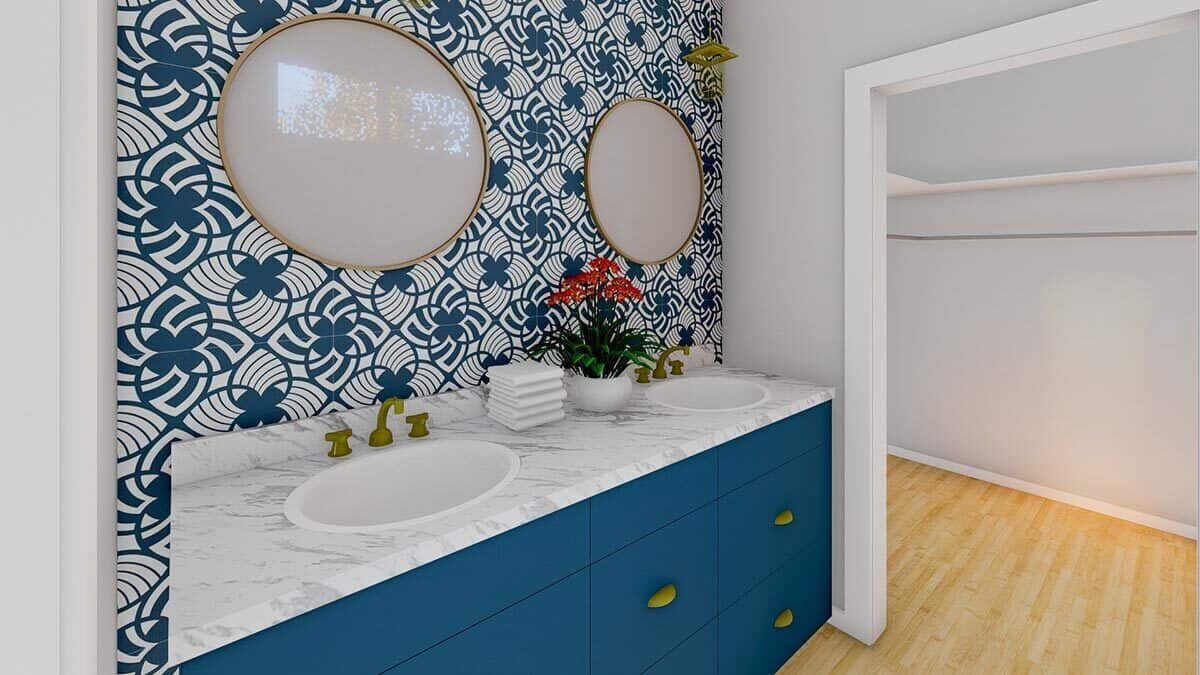 主浴室配有双水槽梳妆台，装饰有蓝色橱柜、黄铜五金和圆形镜子。
