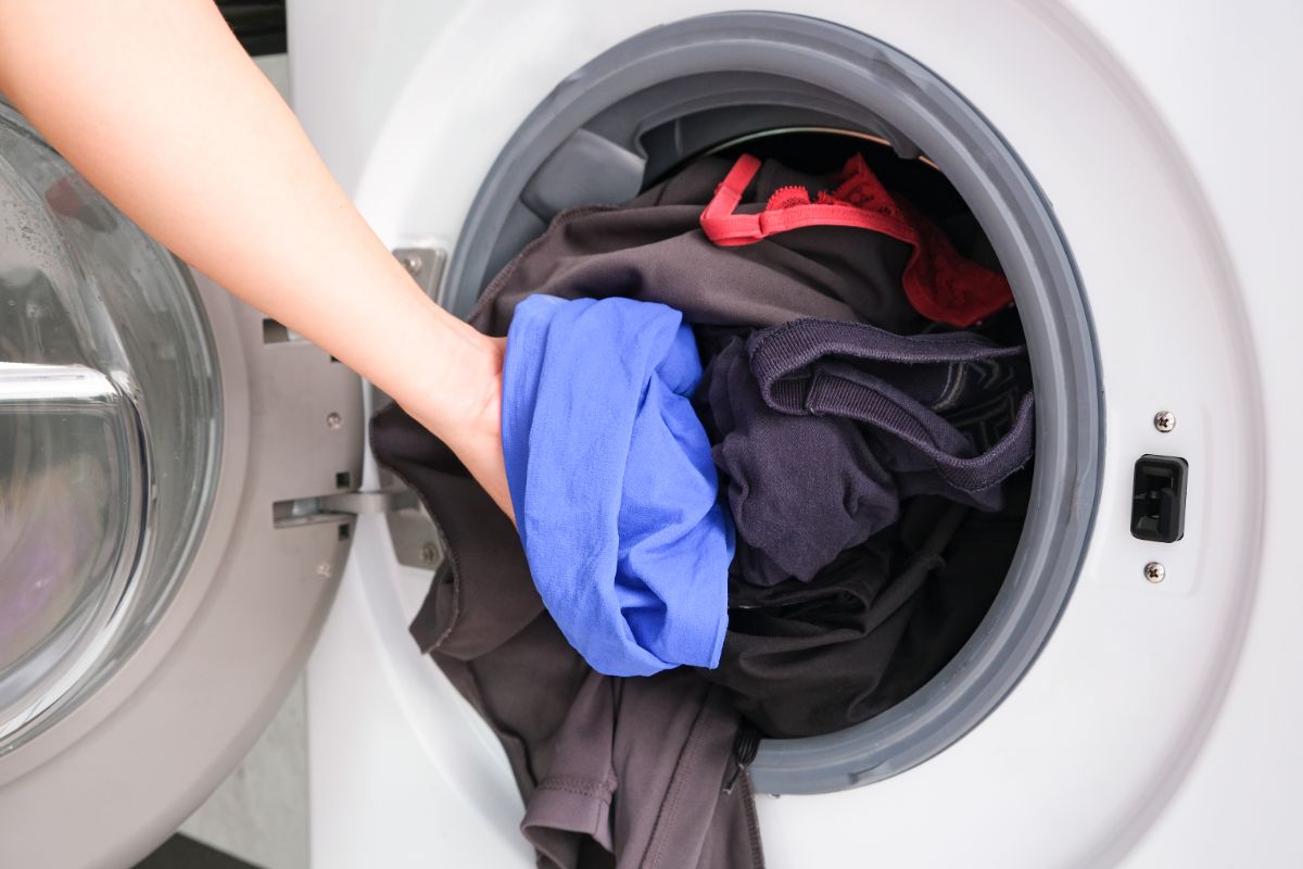 一只手从洗衣机里取衣服。